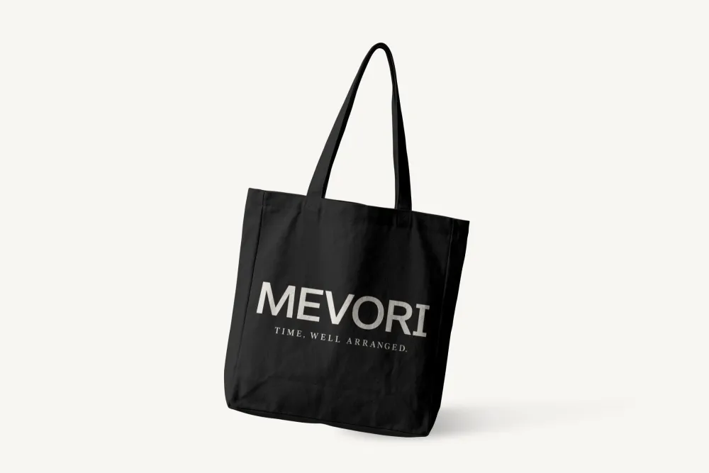 Svart handlenett med MEVORI-ordmerke og slagord i kremhvitt. Mockup.